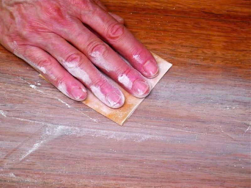 Dùng giấy nhám chà sơn trên sàn nhà